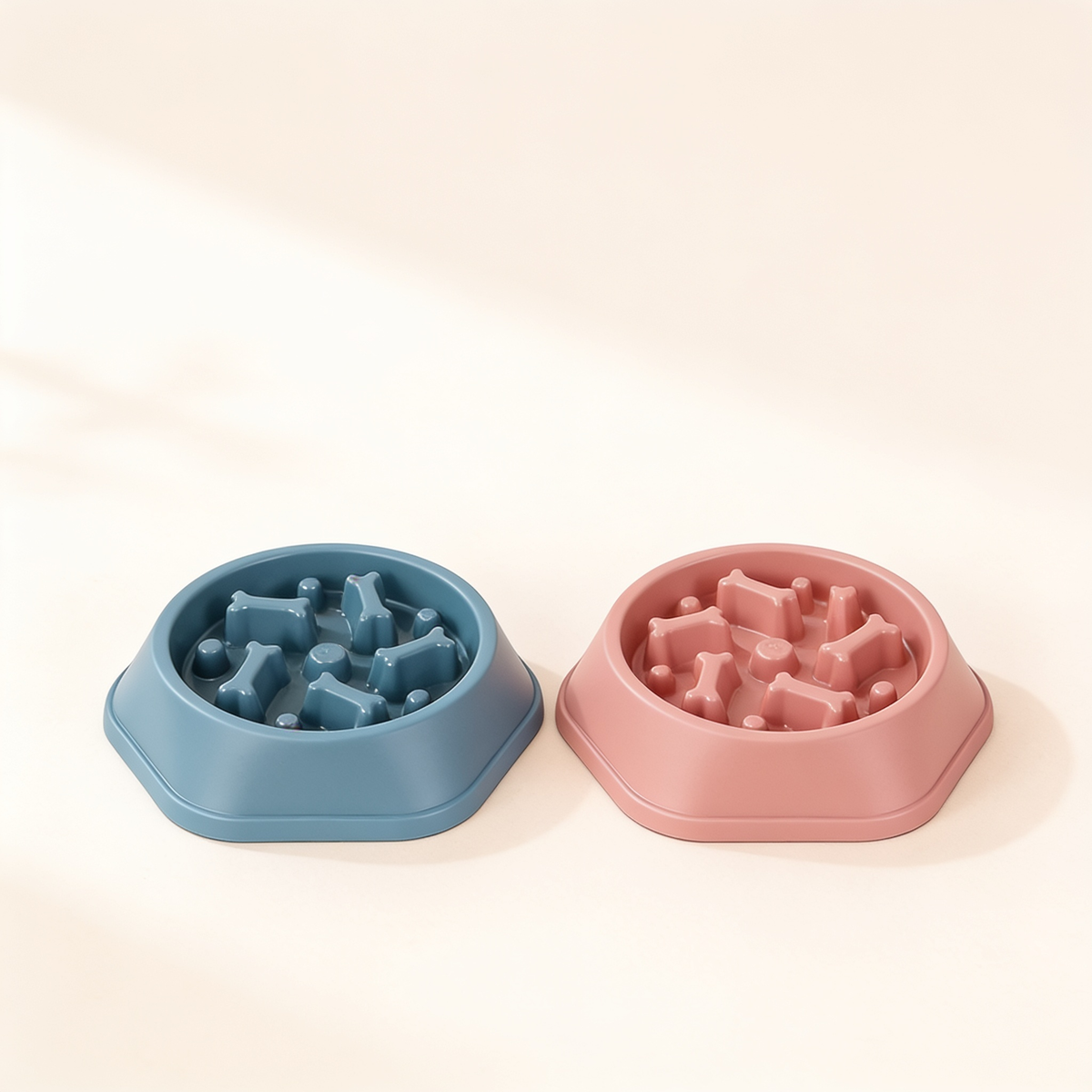 Safe-Pace slow feeder bowls in dusty blue and blush pink showing bone-shaped maze ridges